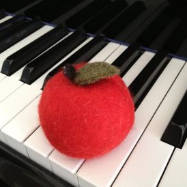 Huovutettu omena pianon kielten päällä